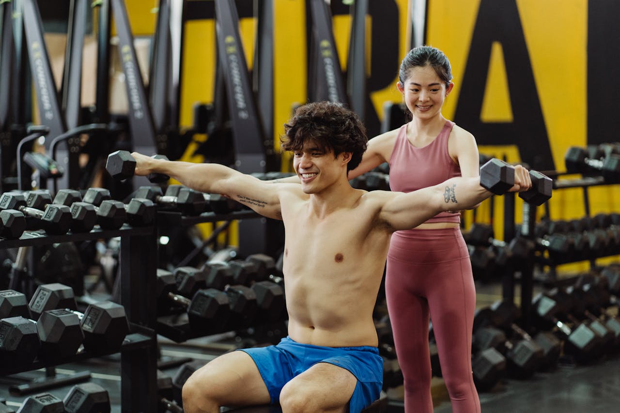 Services Man lifting weights under supervision in a gym, embracing fitness and determination.